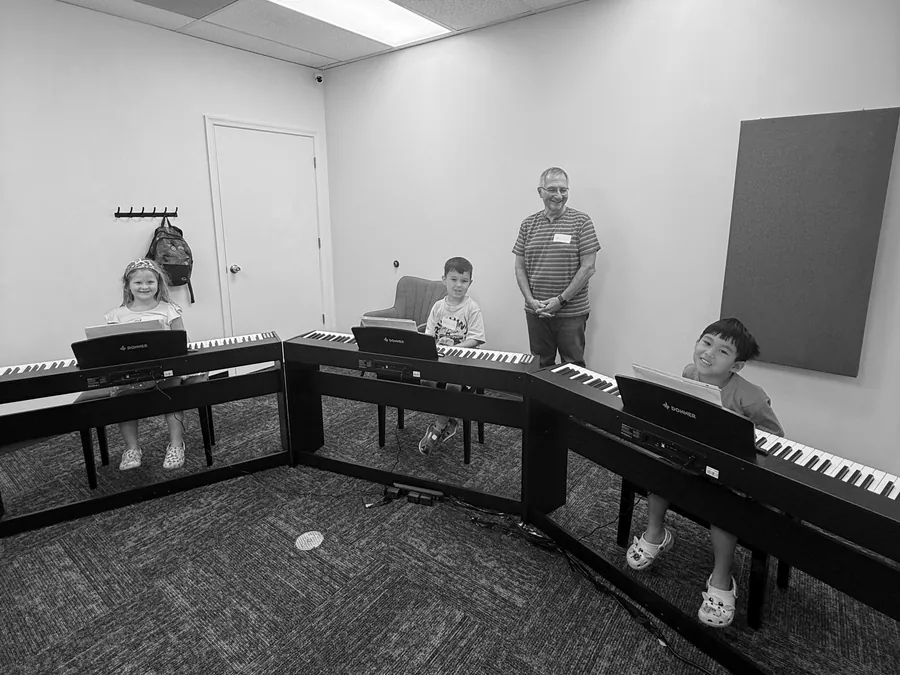 Young Coda Piano School students learning together at keyboards in a group class